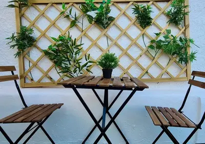 a wooden table with two chairs and plants on a wall at ALGARVE TYPICAL DOWNTOWN HOUSE in Faro