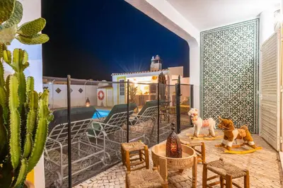 a room with a patio with chairs and a pool at Villa Galé Sun - Luxury, 5bed with free wifi, AC, private pool, 5 min from the beach in Guia