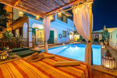 a villa with a pool and a bed in front of it at Riad Serpa Galé - Luxury, private pool, AC, wifi, 5 min from the beach in Guia