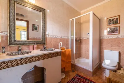 a bathroom with two sinks and a mirror and a shower at Riad Serpa Galé - Luxury, private pool, AC, wifi, 5 min from the beach in Guia