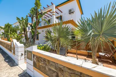 a house with palm trees in front of it at Riad Serpa Galé - Luxury, private pool, AC, wifi, 5 min from the beach in Guia