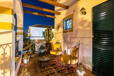 a balcony with two yellow chairs and a cactus at Riad Serpa Galé - Luxury, private pool, AC, wifi, 5 min from the beach in Guia