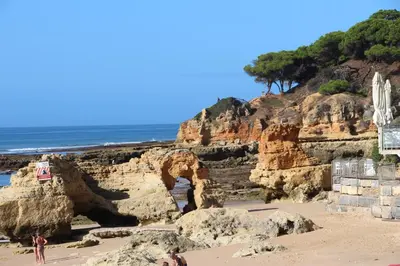 a person standing on a beach near the ocean at Ocean and pool in Olhos de Água