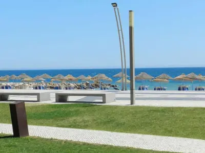 a beach with umbrellas and chairs and the ocean at Quarteira 1-Bed Sleeps 4 Parking 1 min to Beach in Quarteira