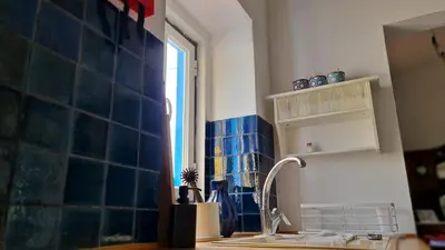 a kitchen with blue tiles and a sink and a window at Monte da ti Luzia in Faro