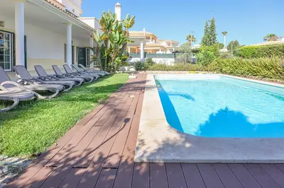 a swimming pool with lounge chairs next to a house at Villa Mar Ali - JACUZZI - 400m from the beach - BY BEDZY in Albufeira