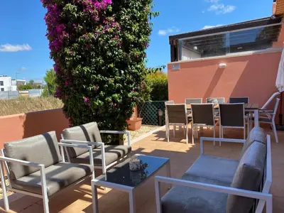 a patio with chairs and a table and flowers at V3 Vitória Boulevard in Vilamoura