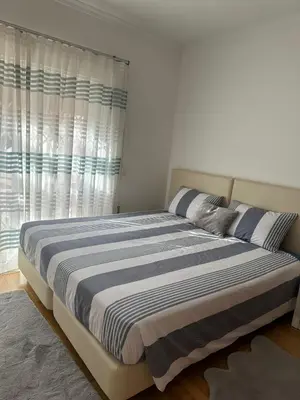 a bedroom with a large bed with a window at V3 Vitória Boulevard in Vilamoura