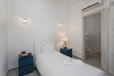 a bedroom with a white bed and a blue night stand at Vilamoura Garden House with Pool & Parking, by Hopstays in Quarteira