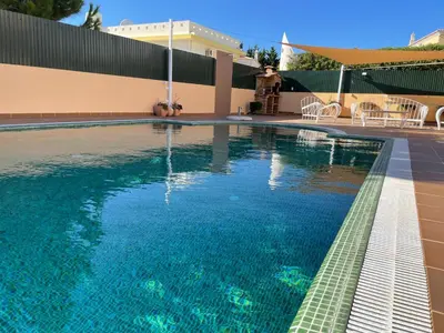 a swimming pool with blue water in front of a building at Villa Mar Azul in Albufeira