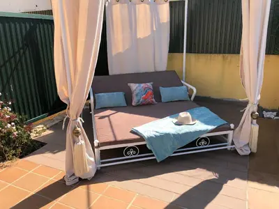 a bed on a porch with a hat on it at Villa Mar Azul in Albufeira