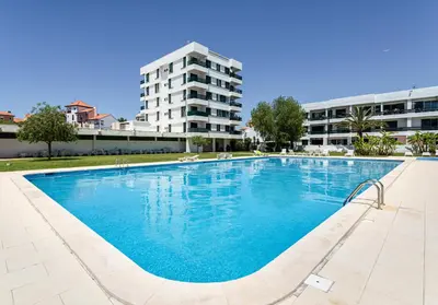 a large swimming pool in front of a building at Neptuno IV - Vilamoura in Quarteira