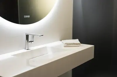 a white bathroom with a sink and a mirror at Marina Luxor - Vilamoura in Quarteira