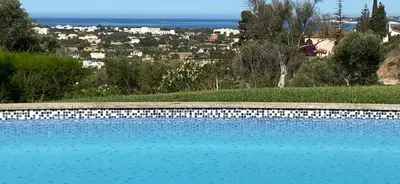 a blue swimming pool with a view of a city at Wonderful View - Quinta da Colina C8 in Albufeira
