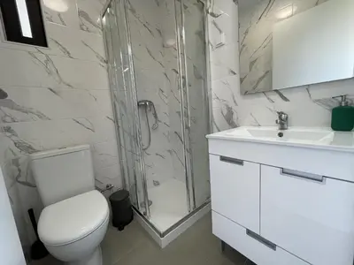 a bathroom with a shower and a toilet and a sink at Vila Flor - Vilamoura in Vilamoura