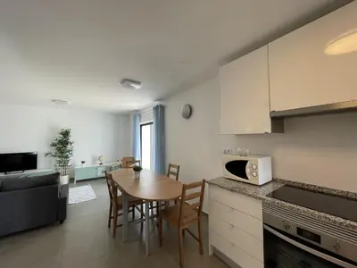 a kitchen and living room with a table and chairs at Vila Flor - Vilamoura in Vilamoura