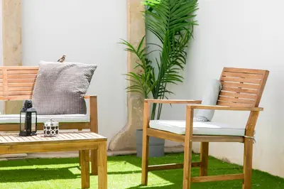 a pair of chairs and a bench on grass at Casa Amarela Guesthouse in Albufeira