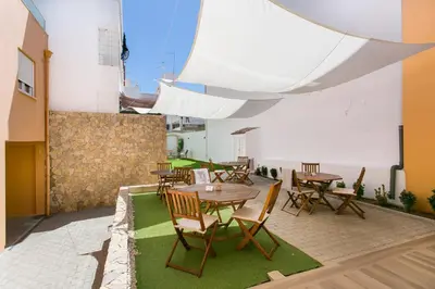 a patio with tables and chairs in a building at Casa Amarela Guesthouse in Albufeira