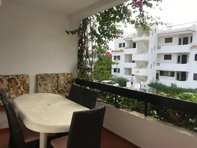 a white table and chairs on a balcony with a building at Comfortable Appartment at Albufeira in Albufeira