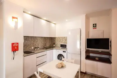 a wooden table with two chairs and a lamp on a patio at #027 T0 Belavista by Home Holidays in Albufeira