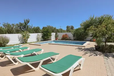 a group of lounge chairs next to a swimming pool at Villa Monte Bixo - Free WIFI . Swimmning Pool - BY BEDZY in Assumadas