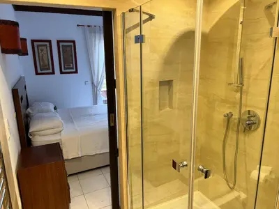 a shower with a glass door in a bedroom at Falesia Beach Town house 2 bedroom in Olhos de Água