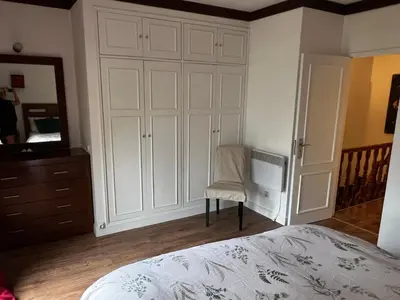a bedroom with a large white cabinet and a chair at Falesia Beach Town house 2 bedroom in Olhos de Água