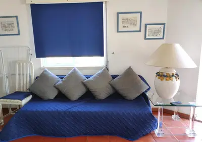 a blue bed with pillows in a room with a window at Cosy studio apartment in Vilamoura in Quarteira