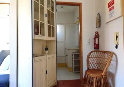 a kitchen with a sink and a chair in a room at Cosy studio apartment in Vilamoura in Quarteira