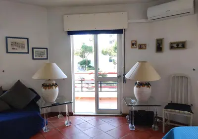 two lamps on tables in a living room with a sliding glass door at Cosy studio apartment in Vilamoura in Quarteira