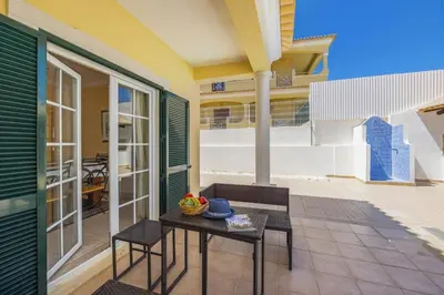 a patio with a table and chairs on a house at Villa Carvalho by Villa Plus in Albufeira