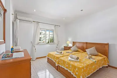 a bedroom with a bed with a yellow bedspread at Villa Carvalho by Villa Plus in Albufeira