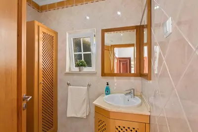 a bathroom with a sink and a mirror at Villa Carvalho by Villa Plus in Albufeira