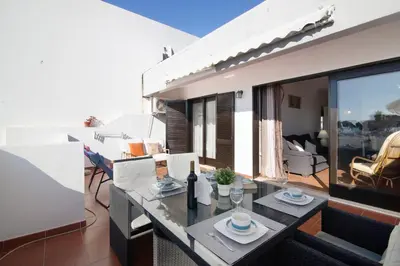 a living room with a table and chairs at T2 Balaia in Albufeira