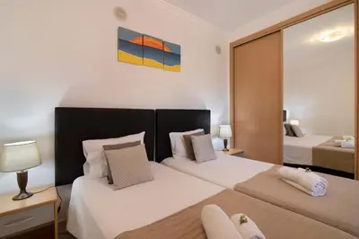 a bedroom with two beds and a large mirror at T2 Bosque de São José in Albufeira