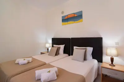 two twin beds in a room with two lamps at T2 Bosque de São José in Albufeira