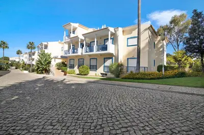 a balcony with a table and chairs and a building at T2 Bosque de São José in Albufeira