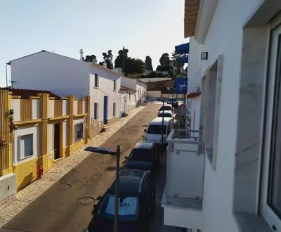a row of cars parked on a street next to buildings at Encosta do Sol Apartamentos in Albufeira