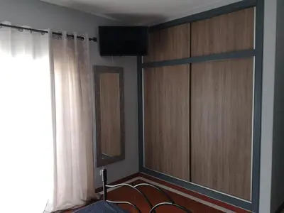 a bedroom with wooden cabinets and a window at Apartamento Recanto do Avô in Albufeira