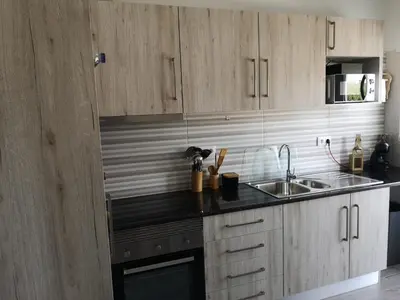 a kitchen with wooden cabinets and a sink at Apartamento Recanto do Avô in Albufeira