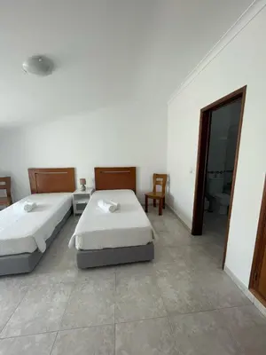 a bedroom with two beds and a bathroom with a mirror at studio para 2 pessoas in Albufeira