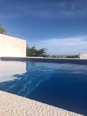 a swimming pool with blue water in front of a building at CASA DO POÇO in Faro