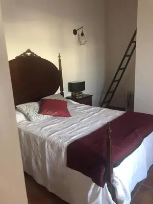 a bedroom with a large bed and a staircase at CASA DO POÇO in Faro