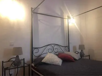 a bedroom with a canopy bed with two lamps at CASA DO POÇO in Faro