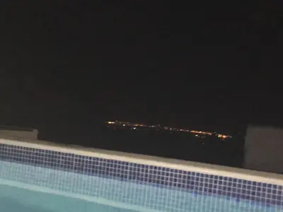 a view of a building at night from a swimming pool at CASA DO POÇO in Faro