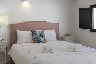 a bedroom with a white bed with two boxes on it at Casa da Praca - City Center - Faro in Faro