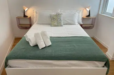 a large white bed with two pillows on it at Janelas Verdes 37 in Faro