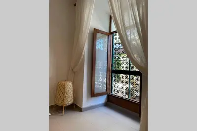 a room with a window with curtains and a chair at Janelas Verdes 37 in Faro