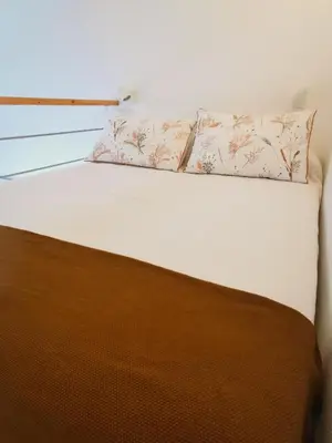 a bed with two pillows on top of it at Tiny House Faro in Faro
