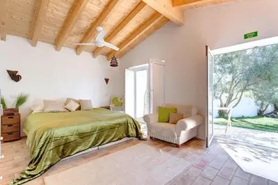 a bedroom with a bed and a chair and a window at Casa De Mondo in Boliqueime